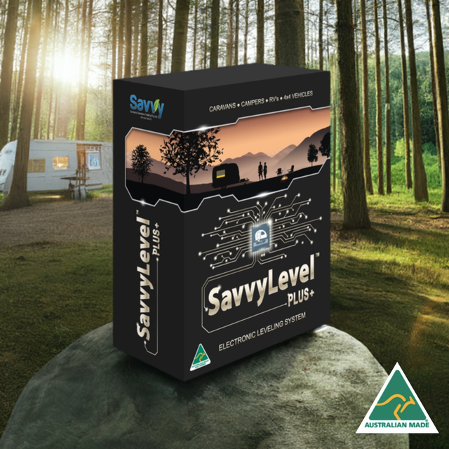 SavvyLevel S4 Levelling Solution box sitting on a rock outdoors. In the background the sun shines through trees against a caravan parked in the grass.